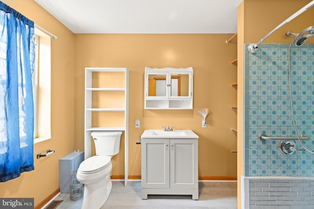 312 S Wolfe St, Baltimore, MD 21231 - bathroom with tiled shower, toilet, vanity, and baseboards