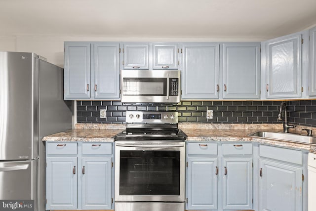 312 S Wolfe St, Baltimore, MD 21231 - kitchen with appliances with stainless steel finishes, a sink, decorative backsplash, and light stone counters