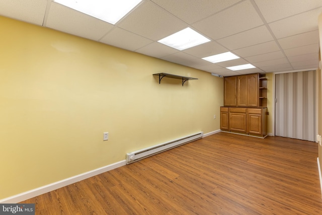 503 Forest Ave, Bellefonte, PA 16823 - empty room with baseboard heating, wood finished floors, baseboards, and a drop ceiling