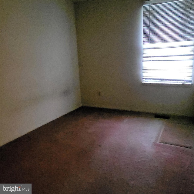 unfurnished room with dark colored carpet