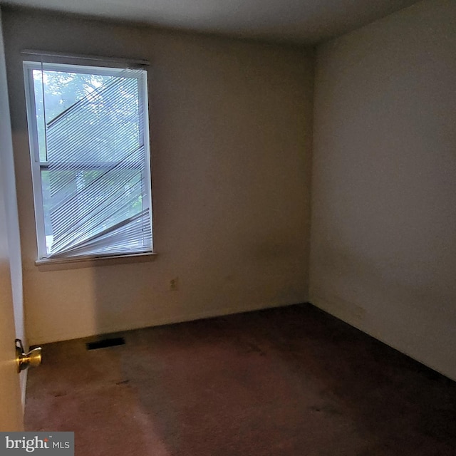 spare room with dark carpet