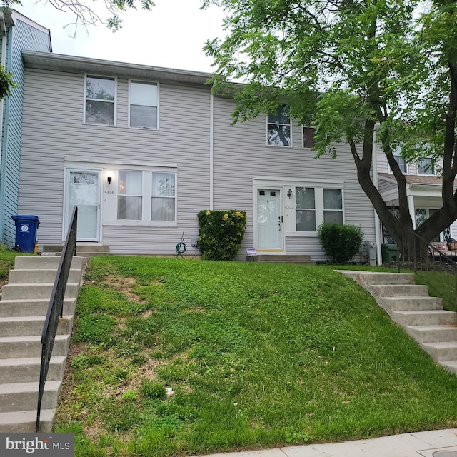 multi unit property with a front lawn and entry steps