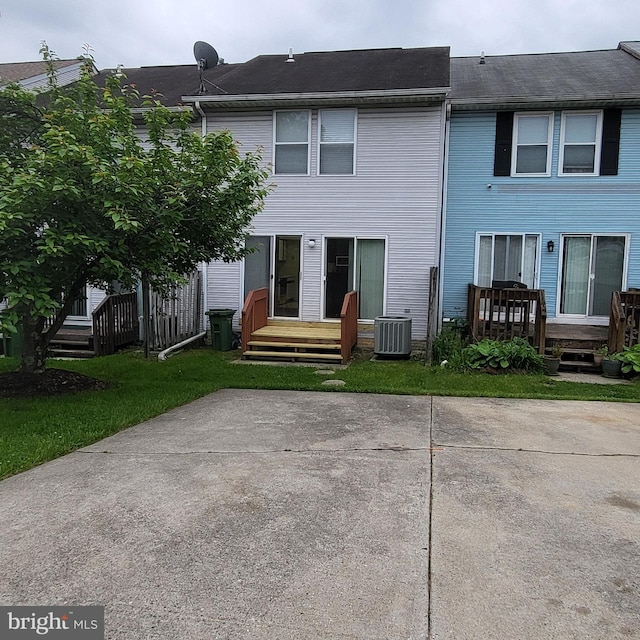 back of property with central air condition unit and a deck