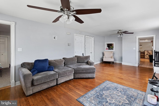 living area with ceiling fan, wood finished floors, and baseboards