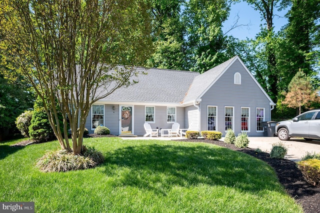 view of front of property featuring a front lawn and a shingled roof