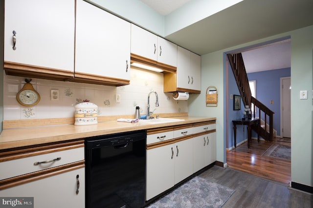 kitchen featuring dishwasher, a sink, dark wood-style floors, backsplash, and white cabinets
