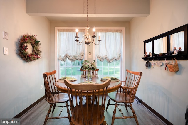 dining room with wood finished floors, a chandelier, and baseboards