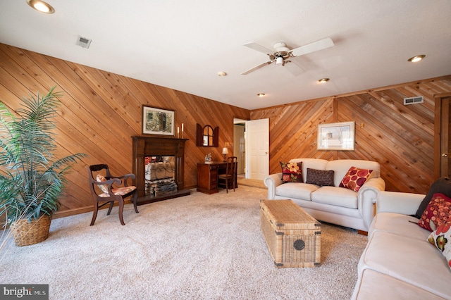 living room featuring carpet flooring, ceiling fan, recessed lighting, a multi sided fireplace, and wood walls