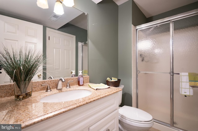 bathroom with a stall shower, toilet, and vanity
