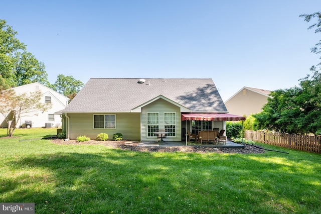 back of house featuring a patio and roof with shingles