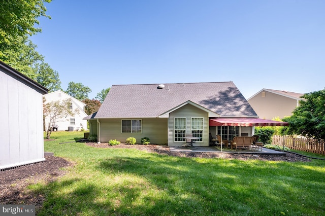 rear view of property featuring a patio area and roof with shingles