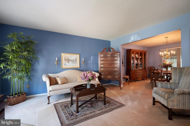 living area featuring a chandelier and carpet
