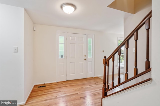5938 New England Woods Dr, Burke, VA 22015 - entrance foyer with healthy amount of natural light, light wood-style floors, and stairway