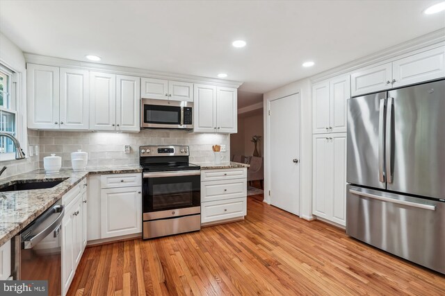 5938 New England Woods Dr, Burke, VA 22015 - kitchen with stainless steel appliances, light wood-type flooring, white cabinets, tasteful backsplash, and recessed lighting