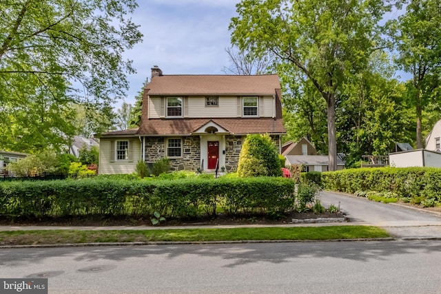 view of front of property featuring a chimney and stone siding