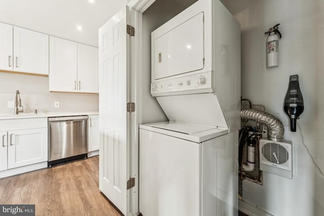 12001 Old Columbia Pike Unit 407, Silver Spring, MD 20904 - laundry area featuring stacked washer and clothes dryer, light wood-style floors, and recessed lighting