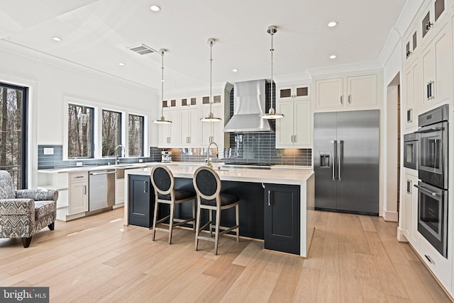 1564 Forest Villa Ln, Mclean, VA 22101 - kitchen with appliances with stainless steel finishes, wall chimney range hood, healthy amount of natural light, light countertops, and recessed lighting