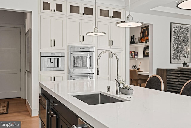 1564 Forest Villa Ln, Mclean, VA 22101 - kitchen featuring double oven, a sink, white cabinetry, light stone counters, and light wood-style flooring