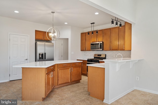 100 Fiesta Dr, Stephenson, VA 22656 - kitchen with stainless steel appliances, backsplash, light countertops, brown cabinets, and pendant lighting