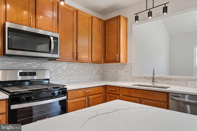 100 Fiesta Dr, Stephenson, VA 22656 - kitchen featuring appliances with stainless steel finishes, a sink, decorative backsplash, light stone countertops, and brown cabinetry
