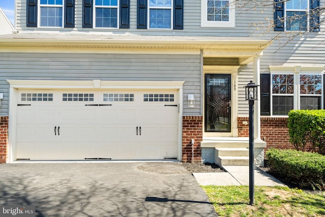 100 Fiesta Dr, Stephenson, VA 22656 - view of exterior entry featuring an attached garage, brick siding, and concrete driveway