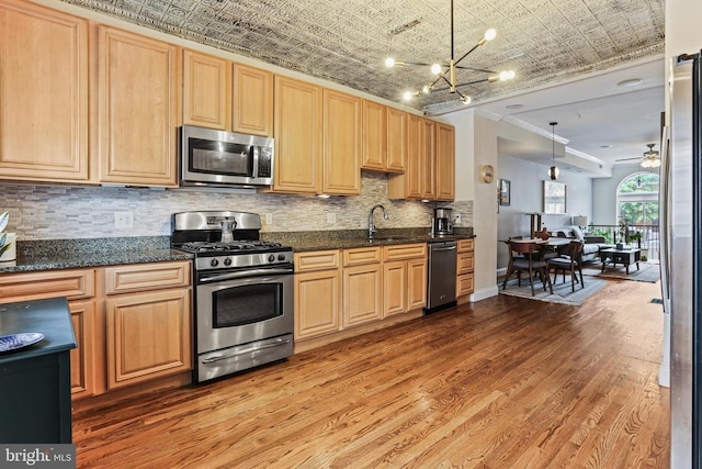 220 S E Ave, Baltimore, MD 21224 - kitchen featuring appliances with stainless steel finishes, an ornate ceiling, wood finished floors, crown molding, and tasteful backsplash