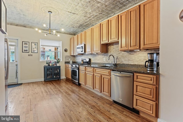 220 S E Ave, Baltimore, MD 21224 - kitchen with appliances with stainless steel finishes, a sink, an ornate ceiling, decorative backsplash, and light wood finished floors