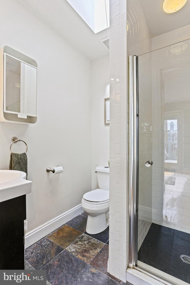 220 S E Ave, Baltimore, MD 21224 - full bath featuring toilet, a shower stall, stone tile flooring, vanity, and baseboards