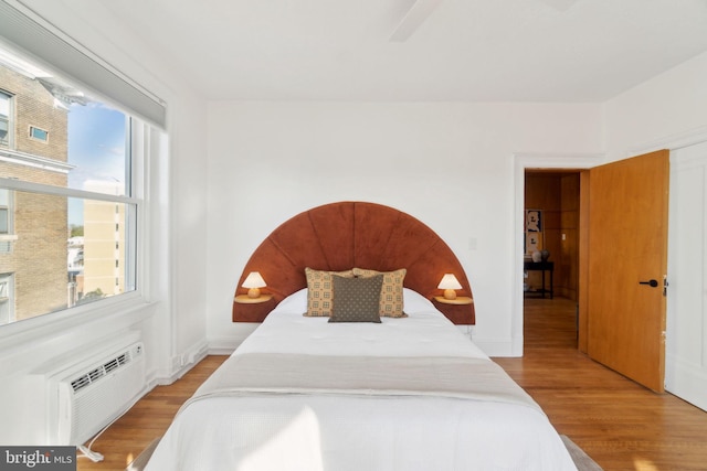 1901 Columbia Rd NW Unit 805, Washington, DC 20009 - bedroom with wood finished floors, an AC wall unit, ceiling fan, and baseboards