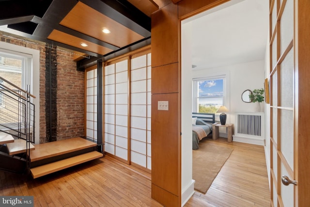 1901 Columbia Rd NW Unit 805, Washington, DC 20009 - hall featuring radiator, wood-type flooring, brick wall, plenty of natural light, and baseboards