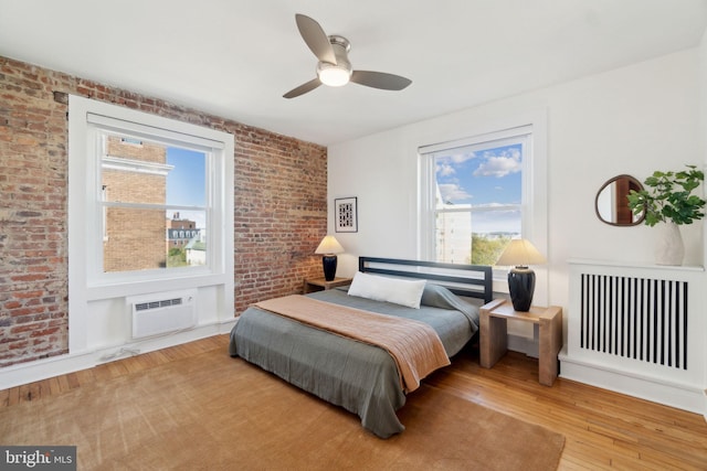 1901 Columbia Rd NW Unit 805, Washington, DC 20009 - bedroom with radiator, an AC wall unit, hardwood / wood-style flooring, brick wall, and a ceiling fan