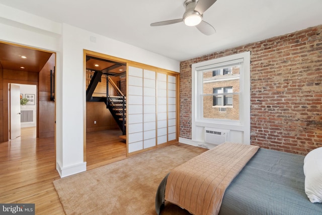 1901 Columbia Rd NW Unit 805, Washington, DC 20009 - bedroom with brick wall, wood finished floors, a wall unit AC, a ceiling fan, and baseboards