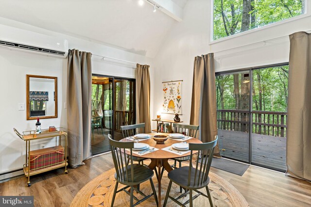 114 Limestone Ln, Berkeley Springs, WV 25411 - dining space featuring a wall unit AC, wood finished floors, rail lighting, high vaulted ceiling, and plenty of natural light