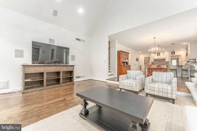 201 Dogwood Slope Rd, Wilmington, DE 19807 - living area featuring stairs, light wood-style flooring, a chandelier, and high vaulted ceiling