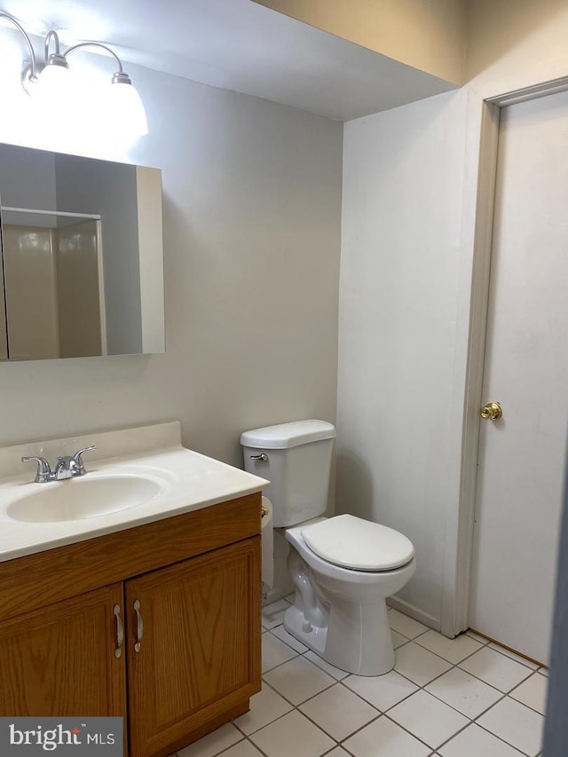 bathroom featuring tile patterned flooring, vanity, and toilet