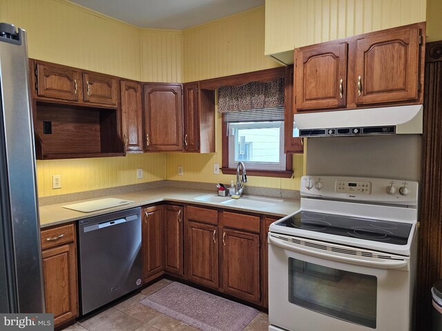 304 Pulaski St, Cumberland, MD 21502 - kitchen featuring appliances with stainless steel finishes, a sink, under cabinet range hood, light countertops, and brown cabinets