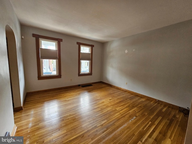 304 Pulaski St, Cumberland, MD 21502 - unfurnished room featuring arched walkways, light wood-style flooring, and baseboards