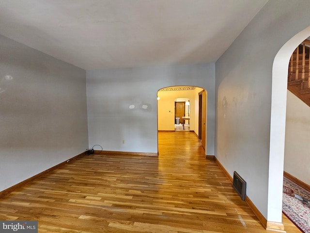 304 Pulaski St, Cumberland, MD 21502 - unfurnished room with arched walkways, wood finished floors, and baseboards