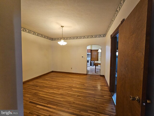 304 Pulaski St, Cumberland, MD 21502 - spare room with arched walkways, wood finished floors, a textured ceiling, and baseboards