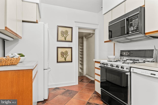 kitchen featuring white appliances, white cabinetry, and light countertops