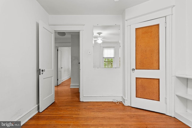 foyer featuring light wood-style floors, a ceiling fan, and baseboards