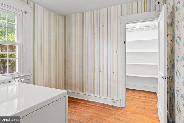 laundry room with light wood-style flooring and wallpapered walls