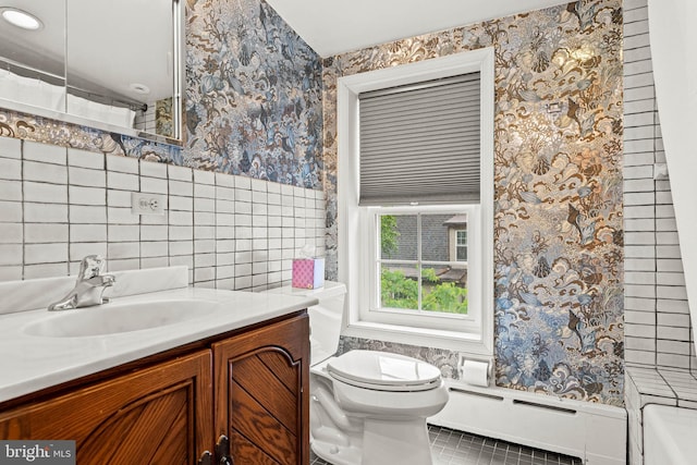 bathroom with wallpapered walls, toilet, a baseboard radiator, vanity, and tile patterned flooring