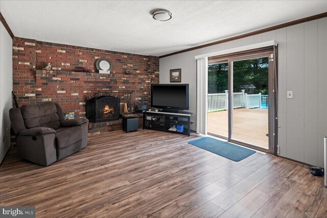 19 Strassberg Ct, Hamilton, NJ 08690 - unfurnished living room featuring wood finished floors, a brick fireplace, ornamental molding, and a textured ceiling