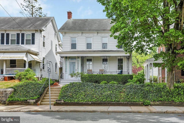 view of front of house featuring covered porch and a chimney