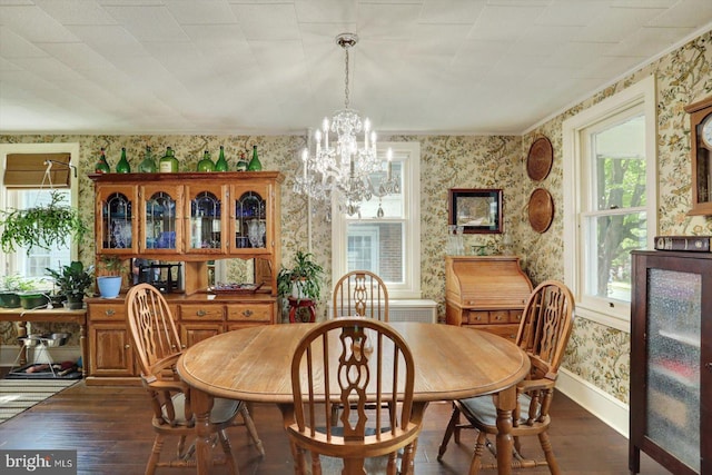 dining room with wallpapered walls, wood finished floors, a chandelier, and baseboards