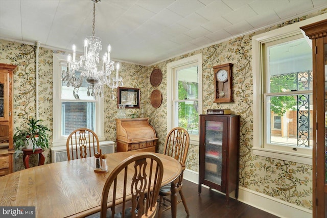 dining area featuring dark wood-style floors, ornamental molding, wallpapered walls, a chandelier, and baseboards