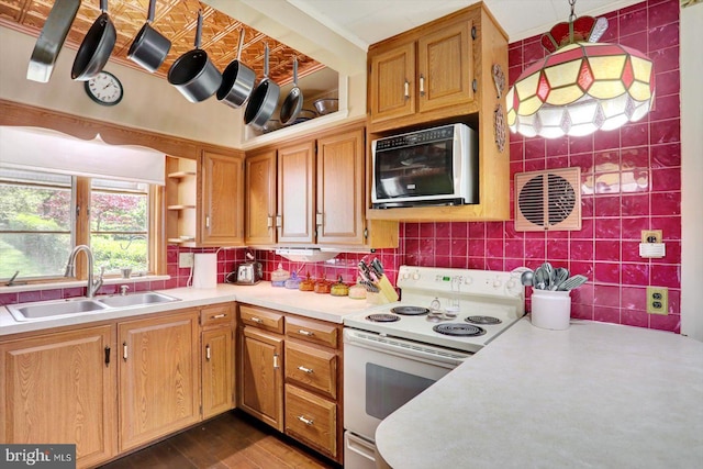 kitchen with white electric range, a sink, light countertops, dark wood finished floors, and backsplash