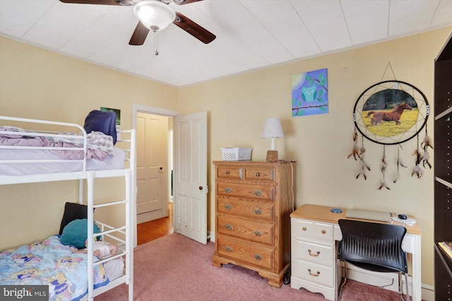 bedroom featuring light colored carpet, a desk, and ceiling fan