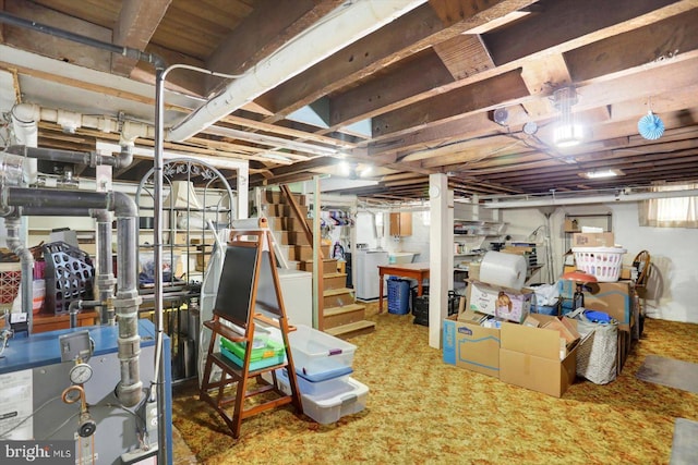basement with a heating unit, stairway, independent washer and dryer, and carpet floors